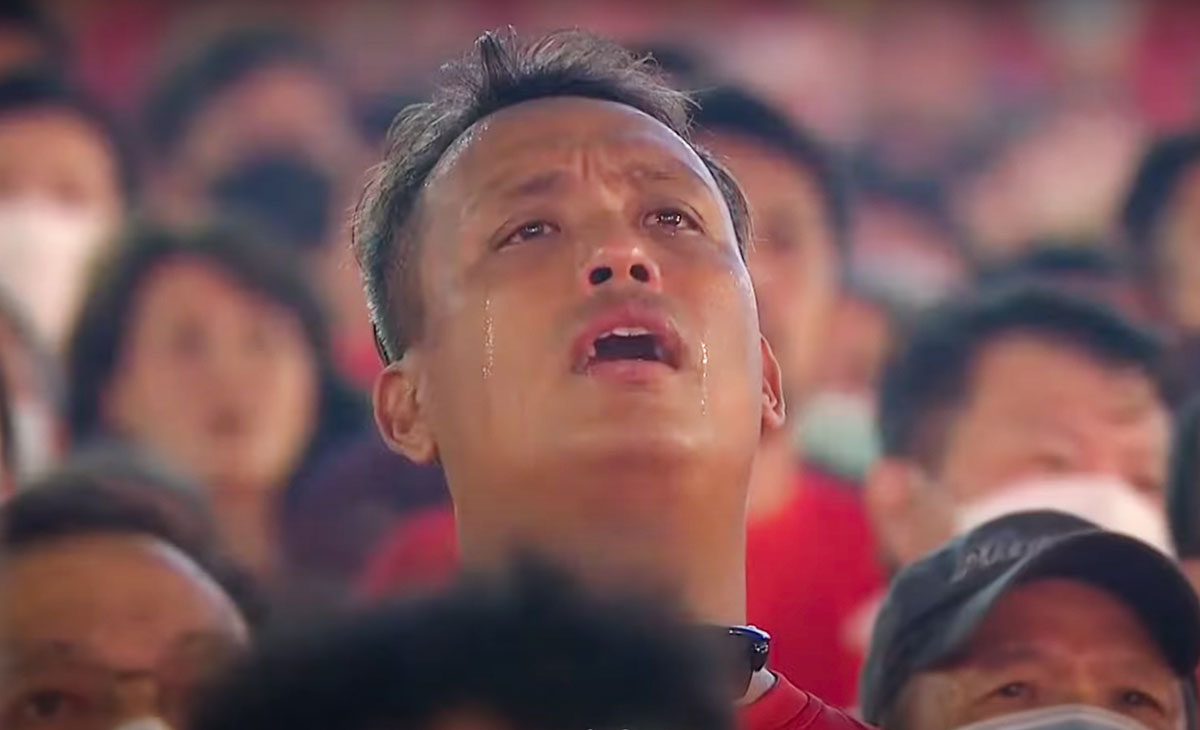 man singing with tears streaming down face